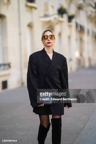 Emy Venturini wears sunglasses from Victoria Bekham, earrings from Toledano, a golden necklace, a black double breasted oversized blazer jacket from...