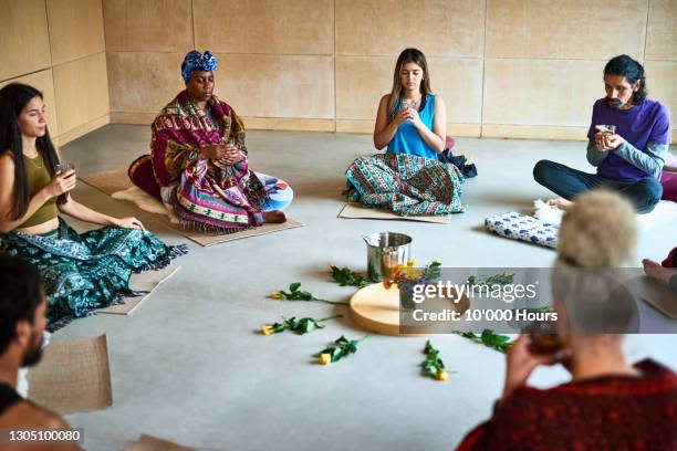 Yoga students sitting in circle for traditional tea ceremony