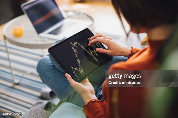 women in business: an anonumous businesswoman using a digital tablet for online trading while working from home - tablet close up real copyspace stock pictures, royalty-free photos & images