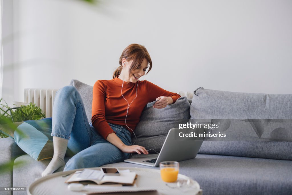 Frauen in der Wirtschaft: Schöne lächelnde Geschäftsfrau mit einem Laptop für Online-Shopping während der Arbeit von zu Hause aus