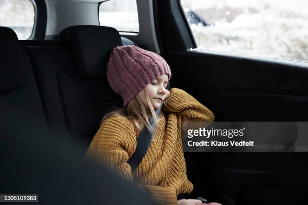 girl sleeping while traveling in car during winter - kid car safety stock pictures, royalty-free photos & images
