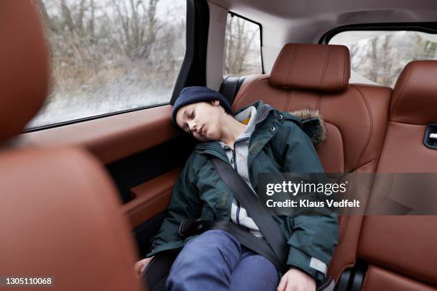 boy sleeping in car during journey - car back seat stock pictures, royalty-free photos & images