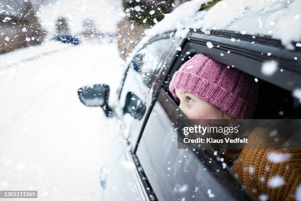 girl looking at snowfall while traveling in car - bilar i snö bildbanksfoton och bilder