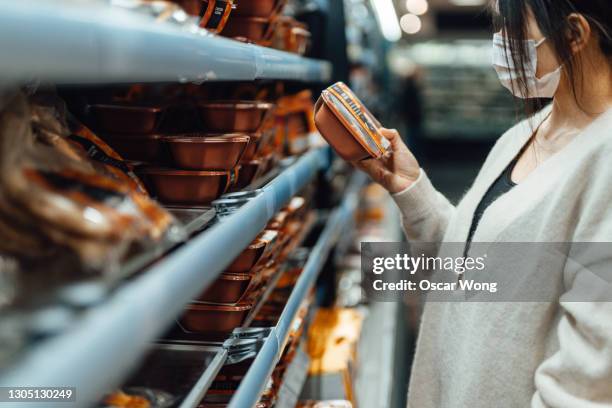 young woman getting food from cooling shelf in supermarket - ready to eat stock pictures, royalty-free photos & images