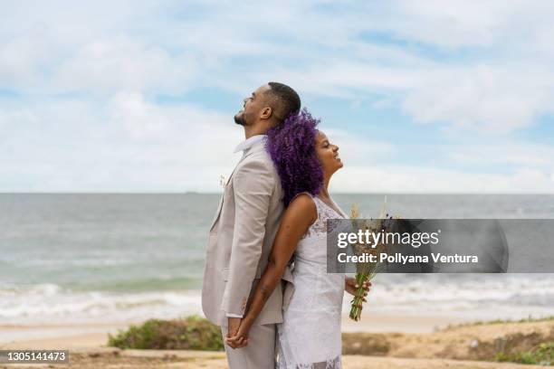 happy young couple with their backs to each other - african ethnicity wedding stock pictures, royalty-free photos & images