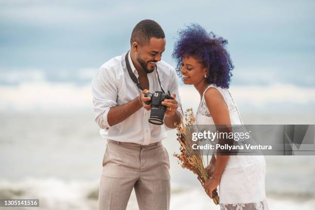 husband shows wedding photos to wife - wedding photographer stock pictures, royalty-free photos & images