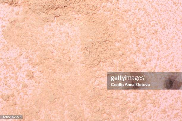 abstract background made with crushed beige invisible face powder on pink background. flat lay style. - make up powder stockfoto's en -beelden