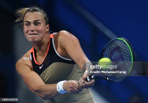 Aryna Sabalenka of Belarus plays a backhand in her Round of 16 singles match against Garbine Muguruza of Spain during Day Three of the Qatar Total...