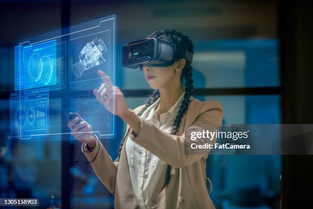 frau trägt ein vr-headset bei der arbeit - virtual reality simulator stock-fotos und bilder