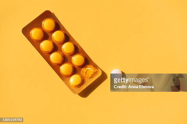 top view of sealed and open blister packs with tablets placed near empty space on yellow background. blister packs with round pills - blister pack stock-fotos und bilder