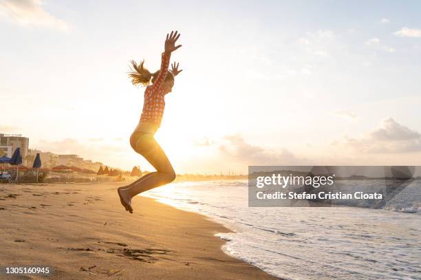 girl jumping on a beach at sunset. crete, greece - crete rethymnon stock pictures, royalty-free photos & images