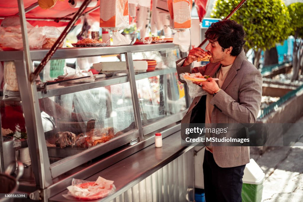 Young businessman garbing quick lunch