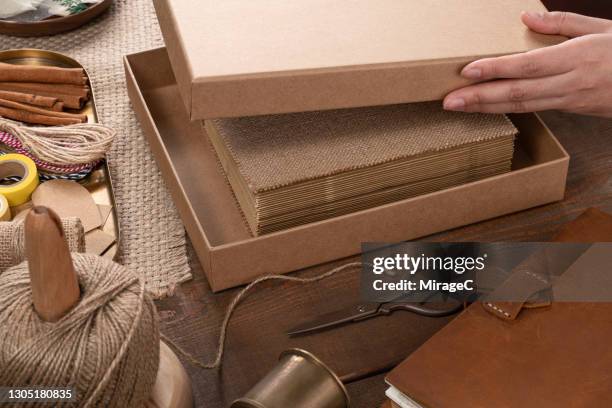 woman's hand lidding gift box for packaging - closing book stock pictures, royalty-free photos & images