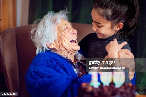 great-grandmother is hugging her great-granddaughter at her 100th birthday - 100 birthday imagens e fotografias de stock