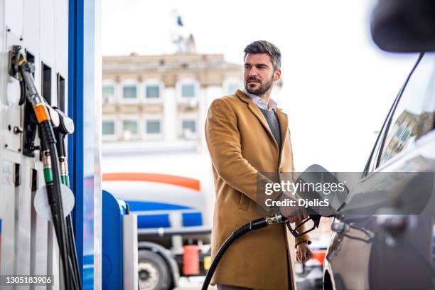 mid adult man at the gas station. - filling petrol stock pictures, royalty-free photos & images