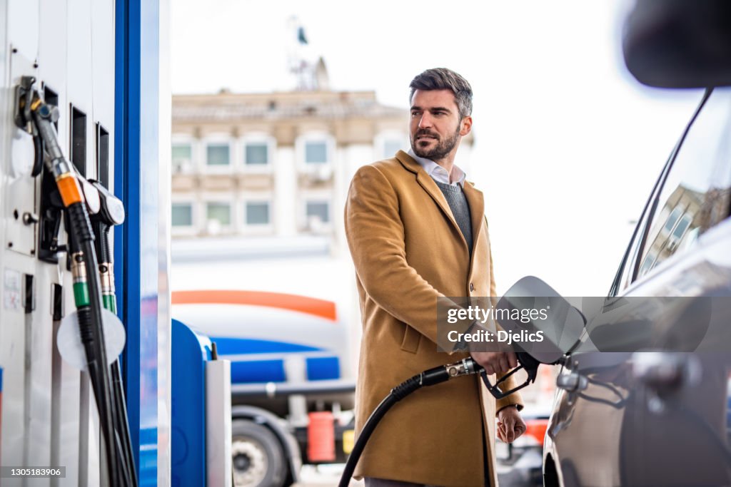 Homem adulto no posto de gasolina.