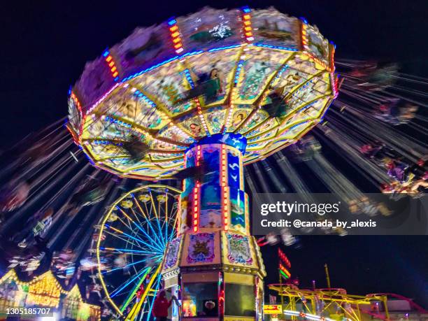 carousel ride by night in calgary - rodeo stock pictures, royalty-free photos & images