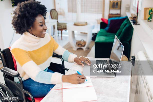 african american woman in a wheelchair working from home - wheelchair stock pictures, royalty-free photos & images
