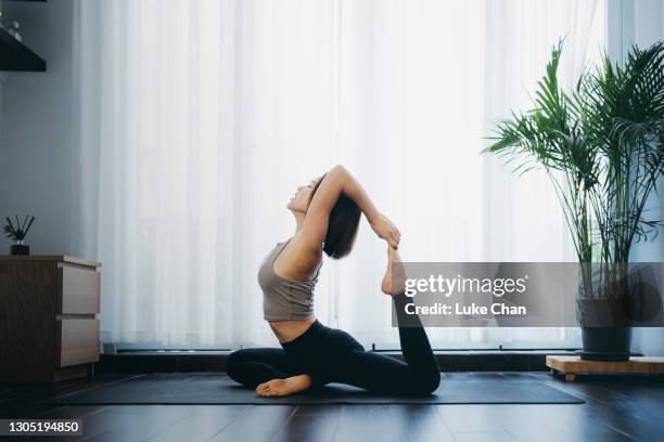 vrouw die yoga thuis praktiseert - gymnastic asian stockfoto's en -beelden