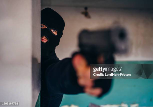 man with a mask holding gun - murderer imagens e fotografias de stock