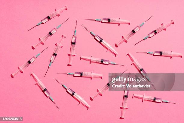 syringe with injection or vaccine repetition pattern on pink background - roze achtergrond stockfoto's en -beelden
