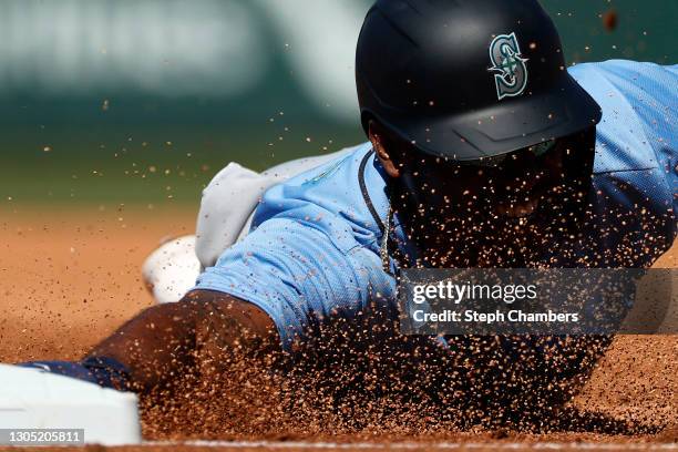 Kyle Lewis of the Seattle Mariners dives back to first base against the Chicago Cubs in the first inning on March 03, 2021 at Sloan Park in Mesa,...