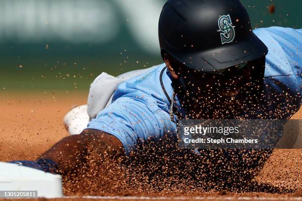 Kyle Lewis of the Seattle Mariners dives back to first base against the Chicago Cubs in the first inning on March 03, 2021 at Sloan Park in Mesa,...