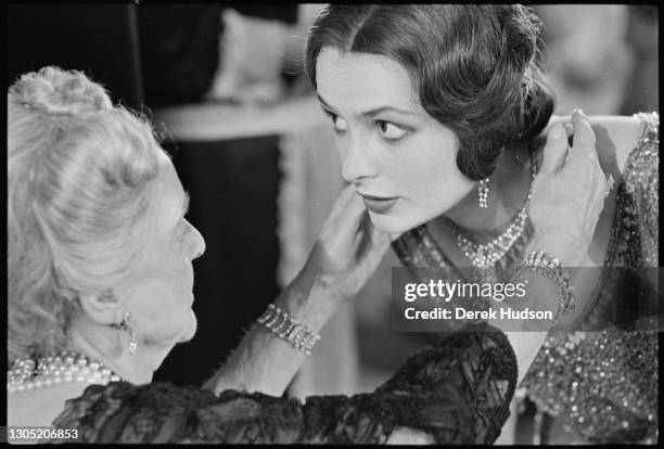 American actress Lois Chiles, a former fashion model, pictured on the film set of Death on the Nile having her hair adjusted by her co-star Bette...