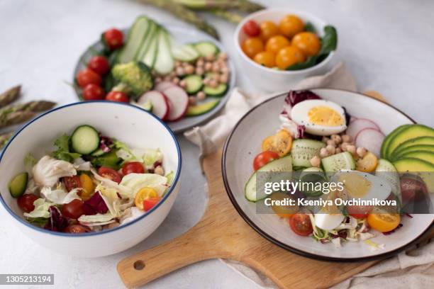 healthy detox dish with egg, avocado, quinoa, spinach, fresh tomato, green peas and broccoli on white wooden background, top view - perfection salad stock pictures, royalty-free photos & images