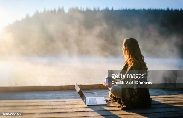 mujer relajándose en la naturaleza y usando tecnología - tranquilidad fotografías e imágenes de stock