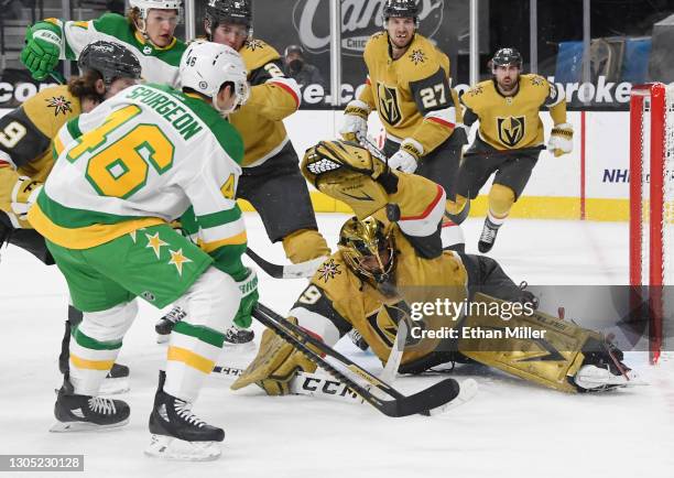 Marc-Andre Fleury of the Vegas Golden Knights makes a glove save against Jared Spurgeon of the Minnesota Wild in the first period of their game at...