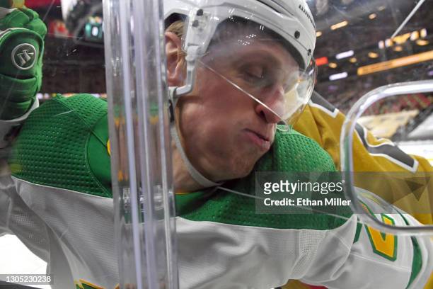 Nick Bjugstad of the Minnesota Wild gets checked into the boards by Shea Theodore of the Vegas Golden Knights in the first period of their game at...