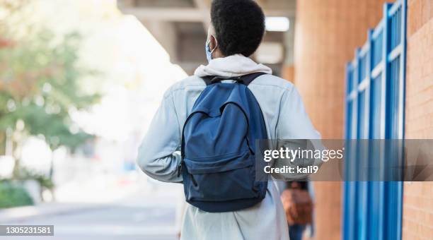 jonge afrikaans-amerikaanse mens die in stad loopt, die masker draagt - rugzak stockfoto's en -beelden