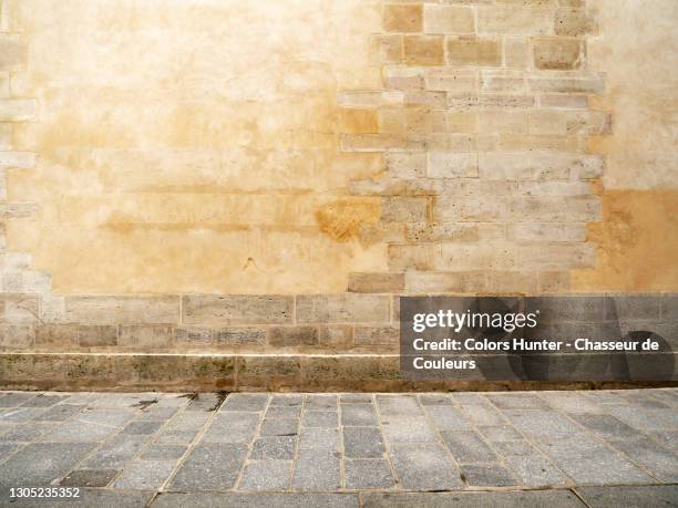 haussmann building facade in weathered stones and sidewalk in paris left bank - stenen muur stockfoto's en -beelden