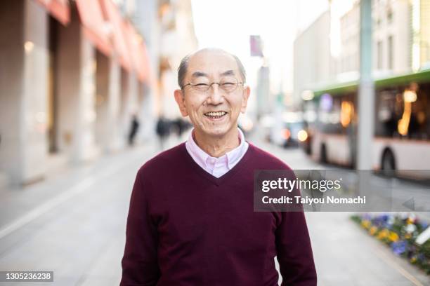 a senior japanese man smiles on the street - public building ストックフォトと画像