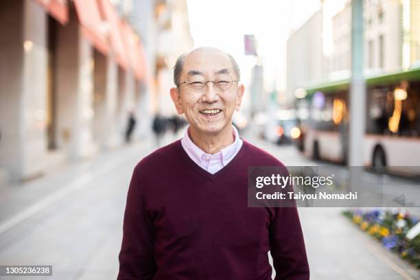 a senior japanese man smiles on the street - old man looking at camera stock pictures, royalty-free photos & images