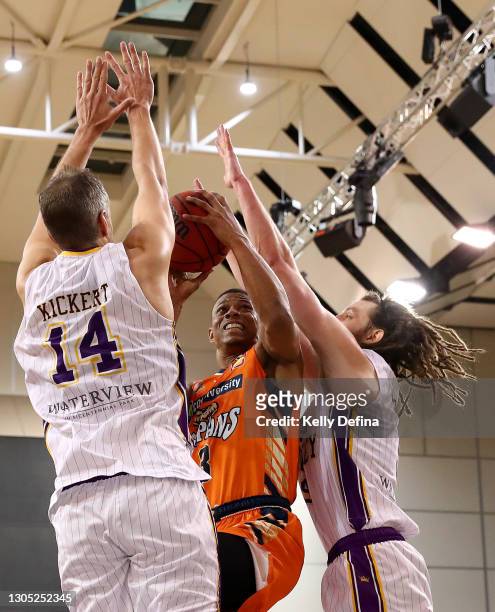 Scott Machado of the Taipans drives to the basket under pressure from Daniel Kickert of the Kings and Craig Moller of the Kings during the NBL Cup...