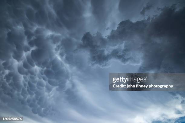 mammatus clouds with a towering cumulonimbus - mammatus cloud stock pictures, royalty-free photos & images