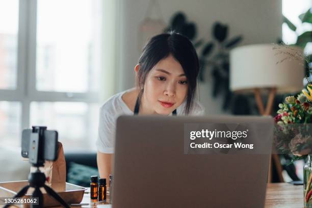young woman entrepreneur running side business online with computer at home - nebenjob stock-fotos und bilder