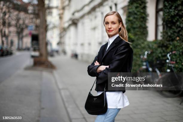 Model Marlies Pia Pfeifhofer wearing a white button down blouse by Prada, a black blazer by Prada, light blue denim jeans pants by Closed and a black...