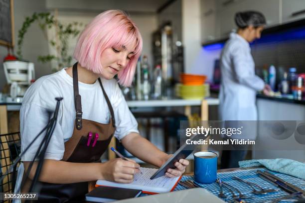 universitaire student die bij koffie voor haar betalingen werkt - part time job stockfoto's en -beelden