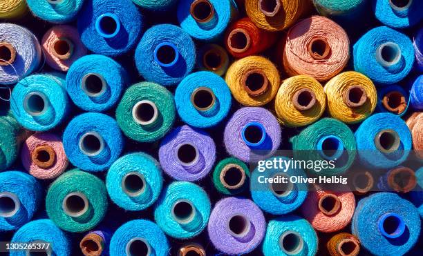 composition of sewing spools with colorful vibrant threads from above - thread stock-fotos und bilder