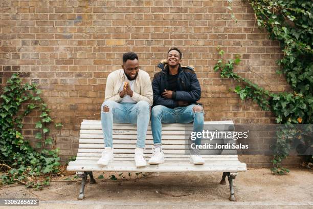 two black males hanging out on the street - bench stockfoto's en -beelden