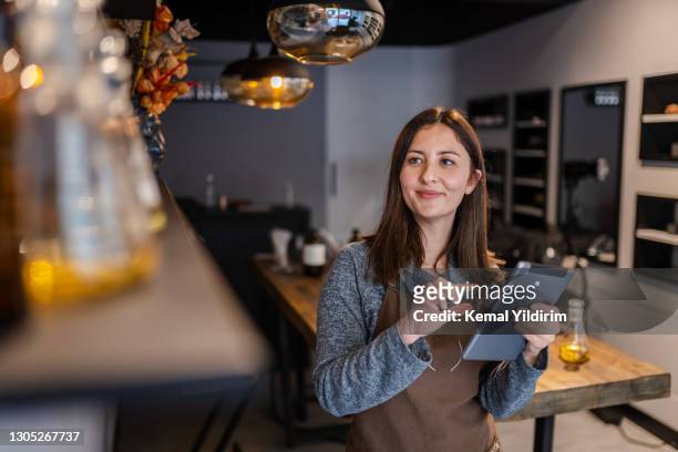 young perfume store owner checking her stock with notepad - financial freedom stock pictures, royalty-free photos & images
