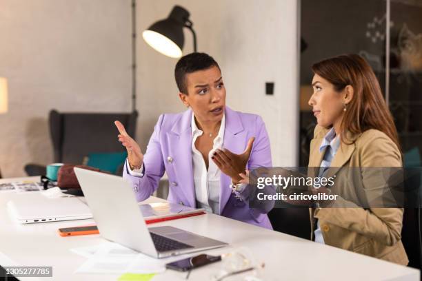 conversazione intensiva di due imprenditrice in ufficio - problemi di comunicazione foto e immagini stock