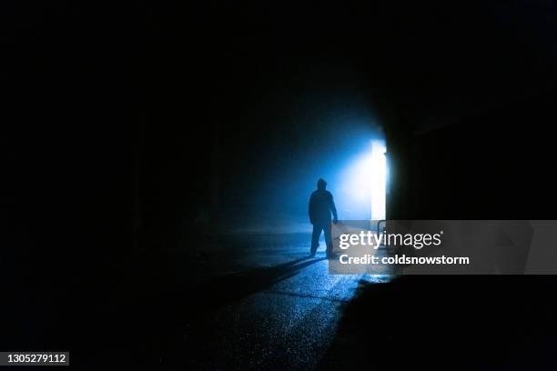 siniestro hombre silueta acechando en las sombras - acosador fotografías e imágenes de stock