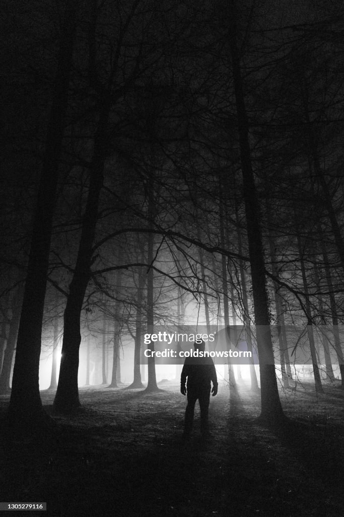 Sinister silhouette man lurking in the shadows