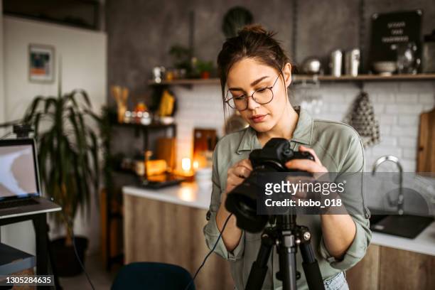 de fotograaf die van de vrouw fotomateriaal voor het ontspruiten voorbereidt - digitale spiegelreflexcamera stockfoto's en -beelden