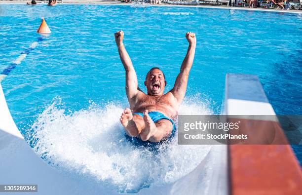 man enjoying on water tobogganing - water park stock pictures, royalty-free photos & images
