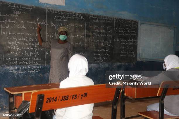 School teacher wearing a facemask lecturing students inside the classroom at Iseyin District Grammar School. Schools in Nigeria have resumed amidst...